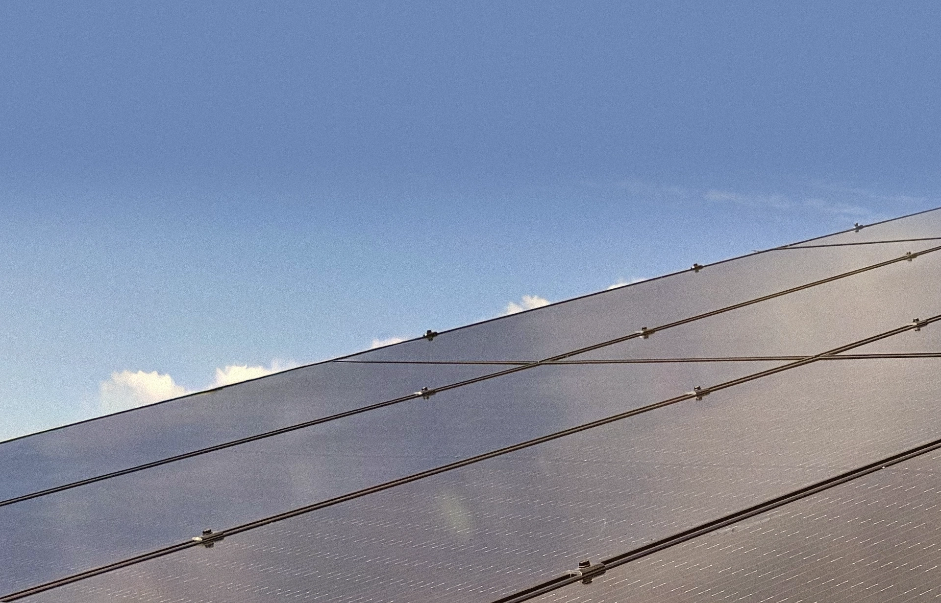 Solar panels on roof against blue sky